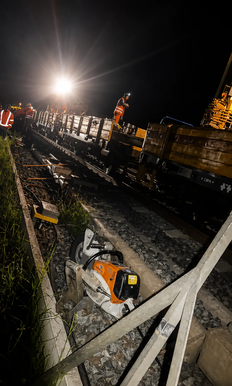 Gleisbauarbeiten bei Nacht mit Trennschleifer am Schienenfuß
